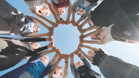 A group of girls makes a circle from their fists of their hands.の写真素材