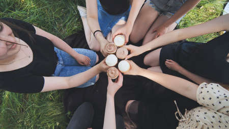 Girls friends join hands with ice cream in waffle cups in a circle.の写真素材