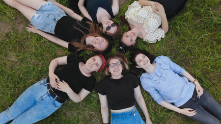 Girls friends lie on the grass like a flower.の写真素材