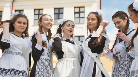 Smiling female graduates pose on the last day of school life.
