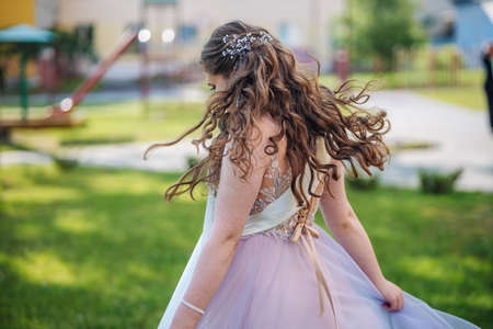 Beautiful schoolgirl in dress at the prom at school.の写真素材