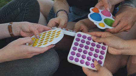 Girls play with simple dimple relaxing toys and pop it.