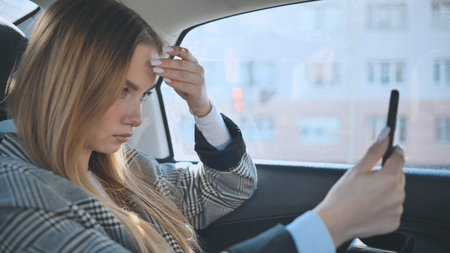 The girl in the car is looking at her phone like its a mirror.