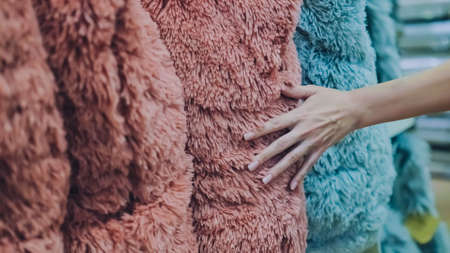 A girl touches her hand over the pillows in the store.の写真素材