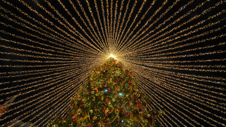 Beautiful illumination in the form of a tent over the New Year tree in the city.の写真素材