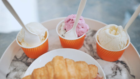 Ice cream and croissant with meat on the plate at the cafe.の写真素材