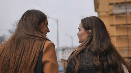 Two brown-haired girls are walking around the city.の写真素材