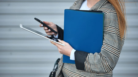 Business woman works with a tablet and a phone.