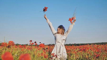 Ukrainian girl tosses poppy flowers in a poppy field.の写真素材