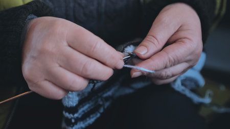 Grandma is knitting a blouse. Close-up of her hands.の写真素材