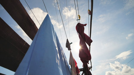 Clothes are drying against a blue sunny sky.