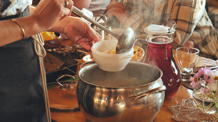 A woman pours hot soup for guests.