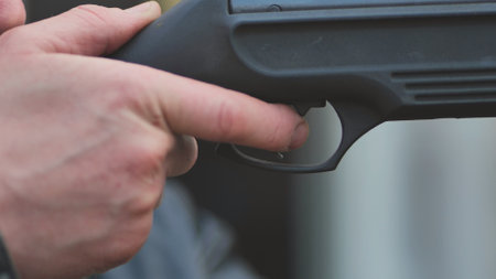 A man firing an air gun. Close-up of her hands.の写真素材