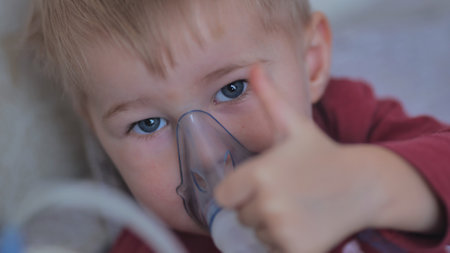 Funny boy breathing through an inhaler mask.の写真素材