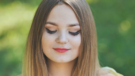 Portrait of a young girl in a park. Close-up of her face.