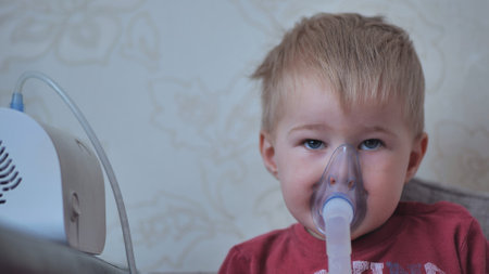 Funny boy breathing through an inhaler mask.の写真素材