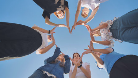 School children make a heart shape from their hands.の写真素材