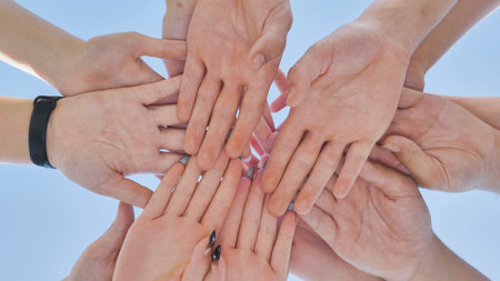 Friends putting their hands together in a sign of unity and teamwork. Just the hands.