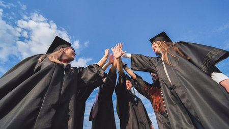 Team of college or university students celebrating graduation. Group of happy successful graduates...