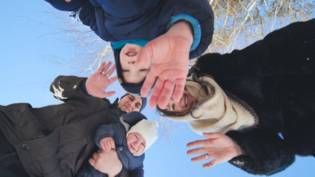 A young family throws snow at the lens on a winter day.の写真素材