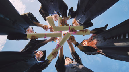 College students stand in a circle wearing black robes.の写真素材