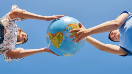 A girl and a guy swivels a globe of the world. The concept of peace and creation.の写真素材