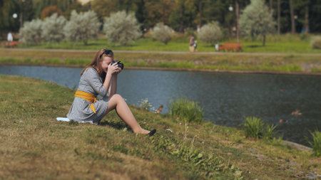 A girl taking pictures with her camera on a summer day.