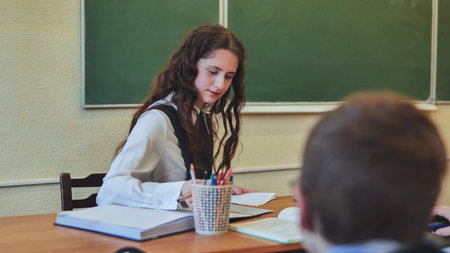 A young female student leads the class in the role of teacher.の写真素材