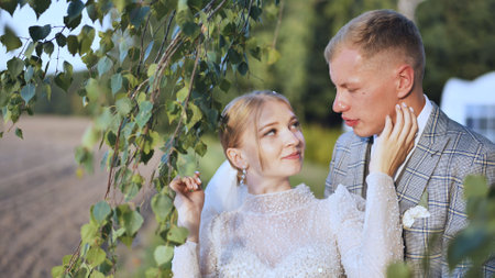 The bride and groom enjoy each other by the branches of a birch tree.の写真素材
