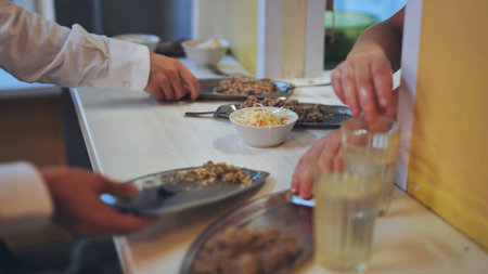 Schoolchildren put down uneaten food in the canteen.