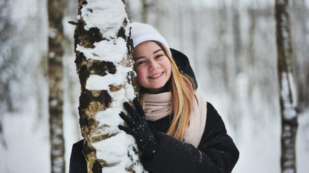 Portrait of a girl in winter in a birch forest.の写真素材