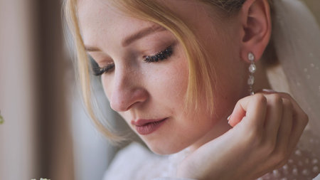 The bride corrects her earring.