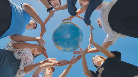Students make a circle around the globe of the world. The concept of world peace.