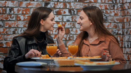 The girls treat each other to slices of pizza.