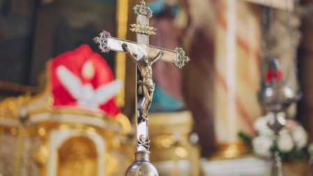 Silver crucifix standing in catholic church with blurred backgroundの写真素材