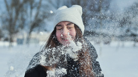 Portrait of a schoolgirl before a snowball arrives in her face.の写真素材