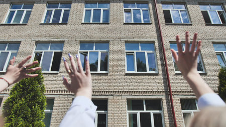 Students waving goodbye on the last day of school, celebrating the end of the academic year with joy...