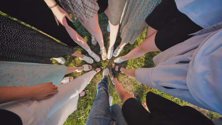 High school students gather in a circle outdoors during the summer, representing unity, friendship,...