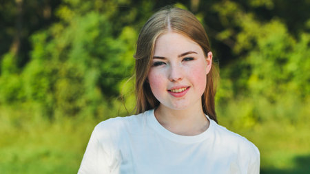 Portrait of a young schoolgirl in a meadow.の写真素材