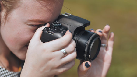 Photographer composing a shot with a dslr camera in natural light, showcasing photography skills and passionの写真素材