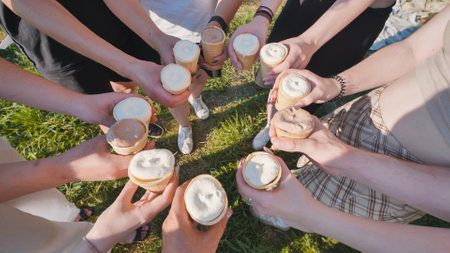 Friends holding ice cream cones in a circle on a sunny dayの写真素材