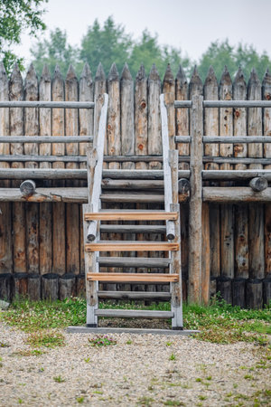 Wooden stairs leading to log reinforced defensive wall inside traditional russian fortress, highlighting medieval architectural techniquesの写真素材