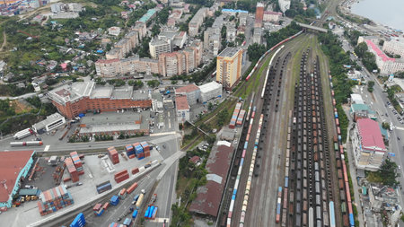 Aerial view capturing a bustling railyard filled with freight trains, shipping containers, and...