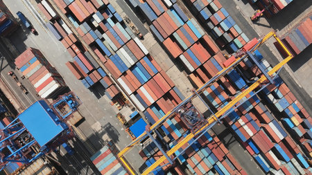 Aerial view of a container terminal with colorful shipping containers and cranes loading and...