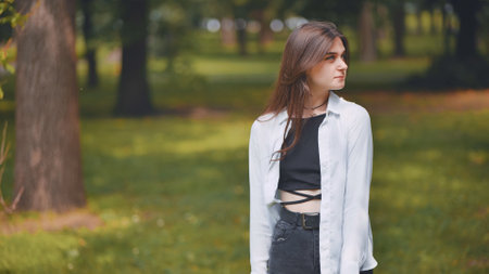Georgian woman relaxing among lush greenery, sitting peacefully under trees, embodying serene connection with natural landscapeの写真素材
