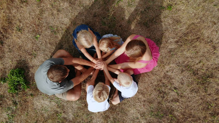 A friendly family joins hands together as a sign of the unity and strength of the family. Drone view.の写真素材