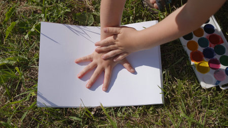 The child leaves a trail of paint with his palm.の写真素材