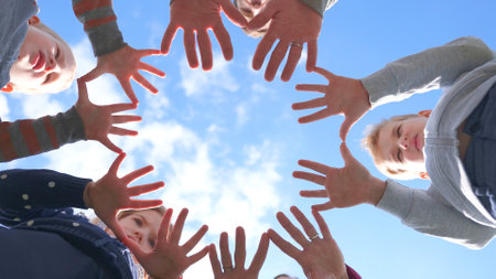 A friendly large family makes a circle shape out of the palms of their hands.の写真素材