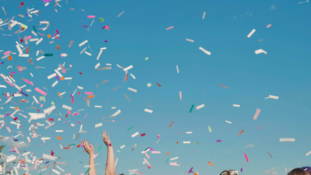 High school graduates joyfully tossing vibrant confetti into the air on a sunny summer day