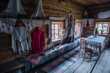Interior of a traditional russian wooden house, displaying folk costumes, furniture, and decorative elements, evoking a sense of history and cultural heritageの写真素材